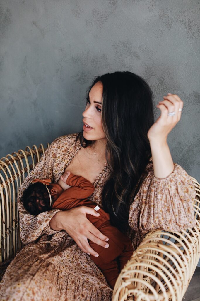 Jill Atogwe breastfeeding youngest daughter on rattan chair